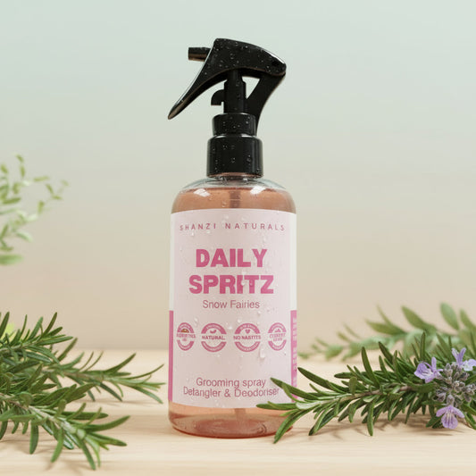 Bottle of 'Daily Spritz' grooming spray on a wooden surface with a striped background