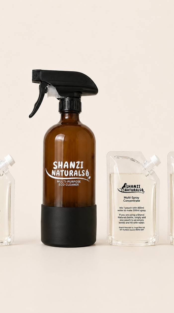 Shanzi Naturals eco cleaner set with a brown spray bottle and three clear containers on a beige background
